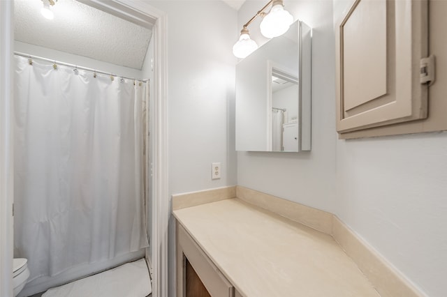 bathroom featuring walk in shower, vanity, toilet, and a textured ceiling