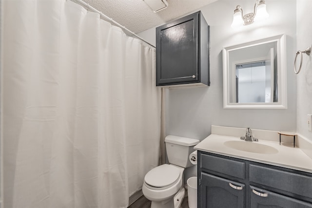 bathroom featuring vanity, a textured ceiling, and toilet