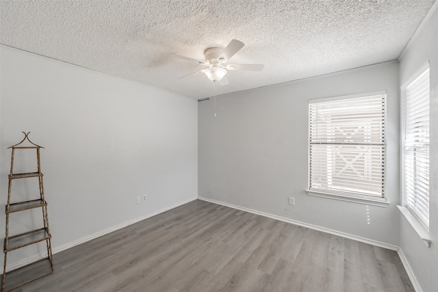 unfurnished room with a textured ceiling, wood-type flooring, and ceiling fan