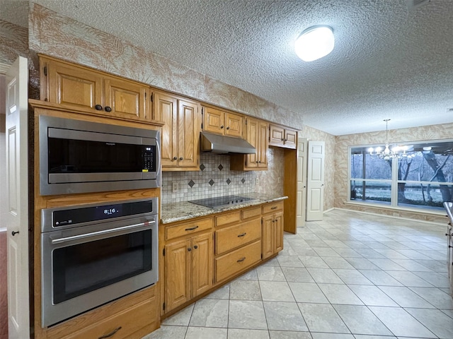 kitchen with stone countertops, stainless steel appliances, a textured ceiling, and light tile patterned flooring