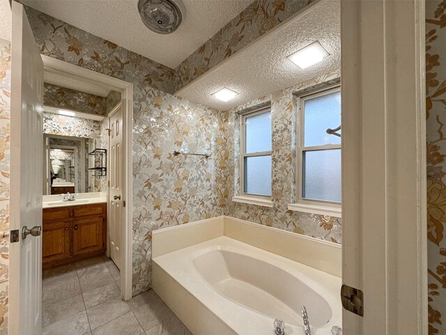 bathroom featuring vanity, a tub to relax in, and tile patterned floors