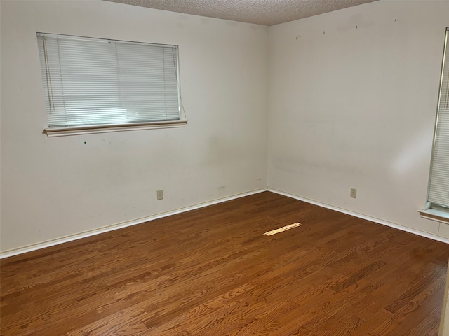 empty room with a textured ceiling and hardwood / wood-style floors