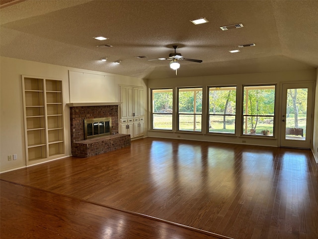 unfurnished living room featuring a textured ceiling, a fireplace, wood-type flooring, and ceiling fan