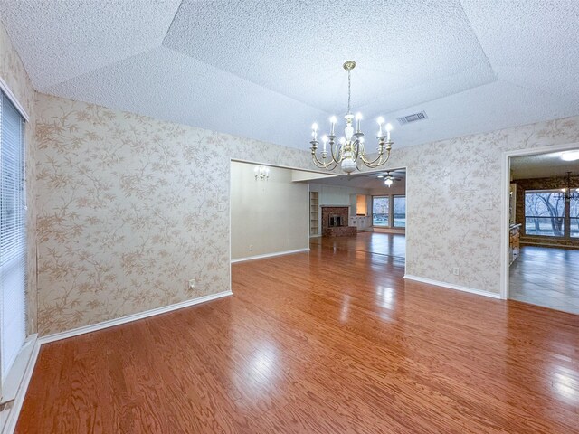 unfurnished living room with a textured ceiling, dark wood-type flooring, and a brick fireplace