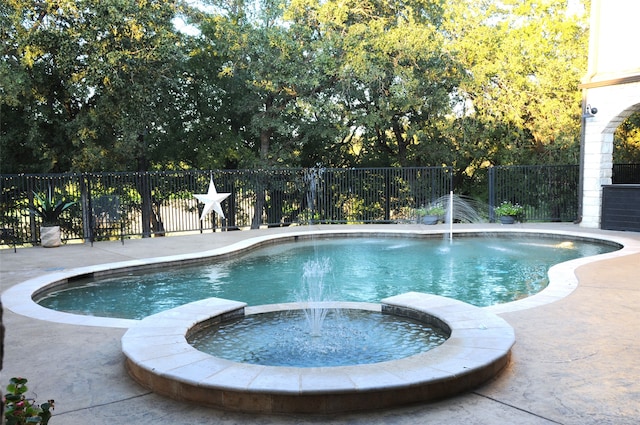 view of pool featuring an in ground hot tub, pool water feature, and a patio