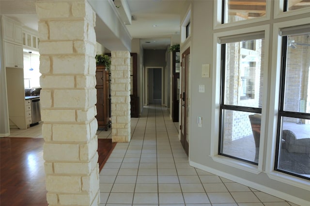 hall with light tile patterned floors, visible vents, and baseboards