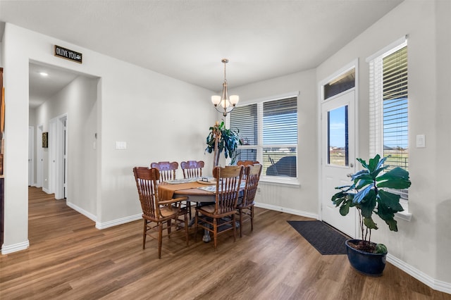 dining area with a chandelier and dark wood-type flooring