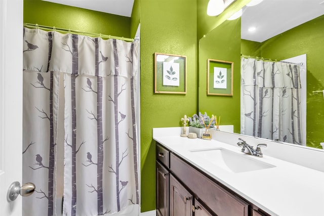 bathroom with curtained shower and vanity