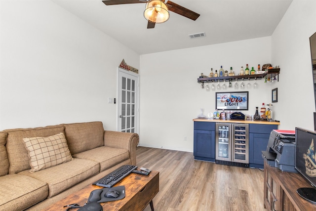 interior space featuring indoor bar, light hardwood / wood-style flooring, beverage cooler, and ceiling fan