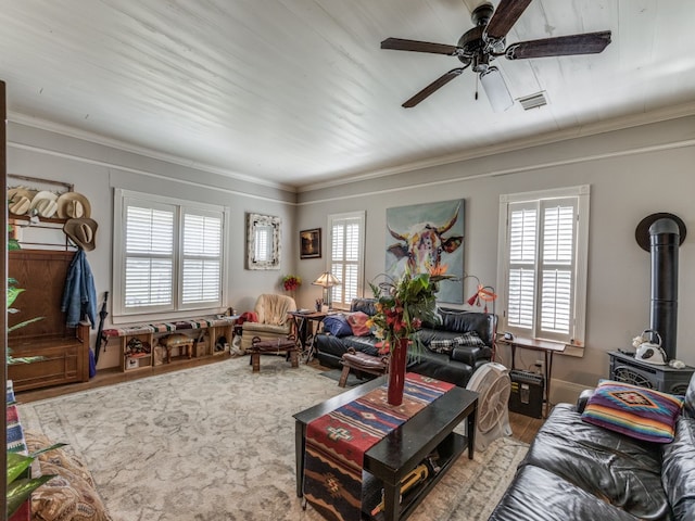 living room featuring a wood stove, ceiling fan, hardwood / wood-style flooring, and crown molding