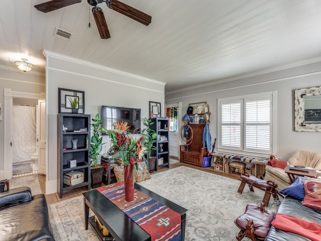 living room featuring wood-type flooring, crown molding, and ceiling fan