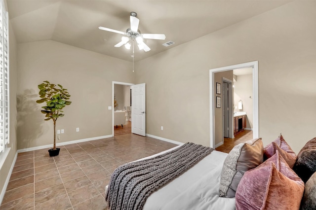 tiled bedroom featuring ceiling fan, ensuite bath, and vaulted ceiling