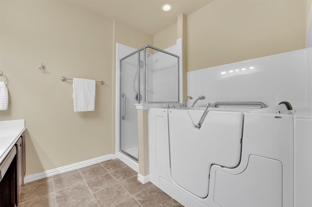 bathroom featuring vanity, a shower with shower door, and tile patterned floors