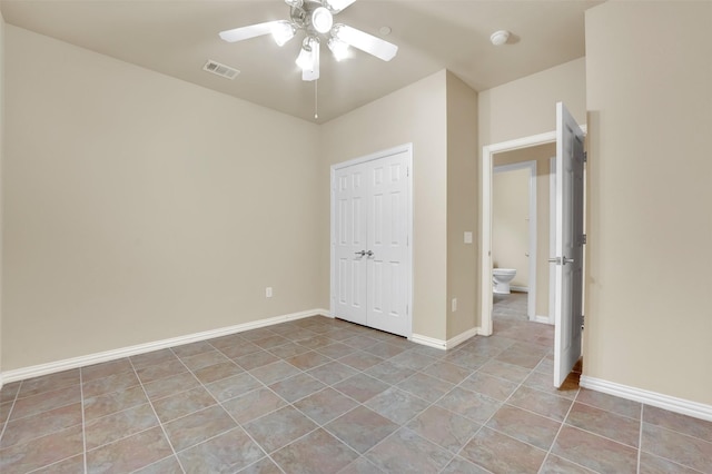 unfurnished bedroom with light tile patterned floors, a closet, and ceiling fan