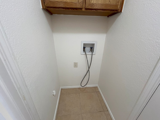 laundry area with cabinets, washer hookup, and light tile patterned floors