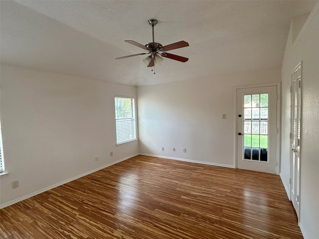 spare room with a textured ceiling, dark hardwood / wood-style flooring, and ceiling fan