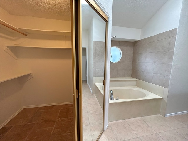 bathroom featuring plus walk in shower, a textured ceiling, and tile patterned floors