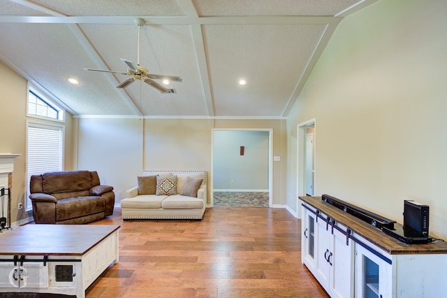 living room with a textured ceiling, light wood-type flooring, and lofted ceiling