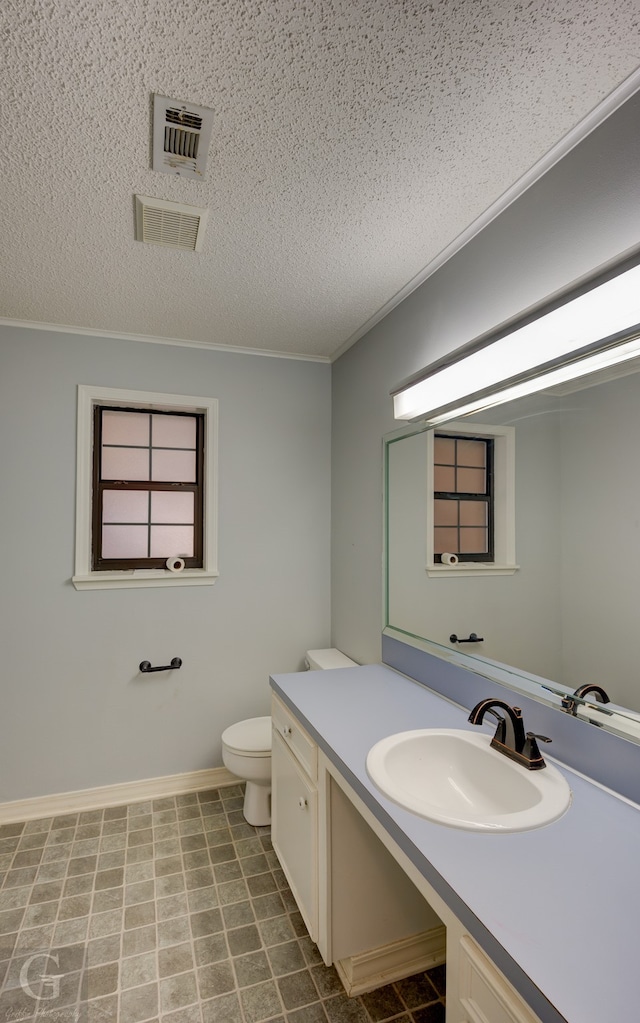 bathroom with vanity, toilet, and a textured ceiling