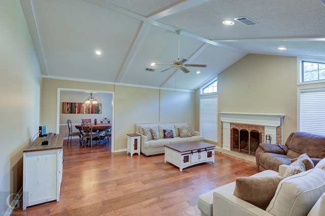 living room featuring hardwood / wood-style flooring, lofted ceiling, a fireplace, and a wealth of natural light