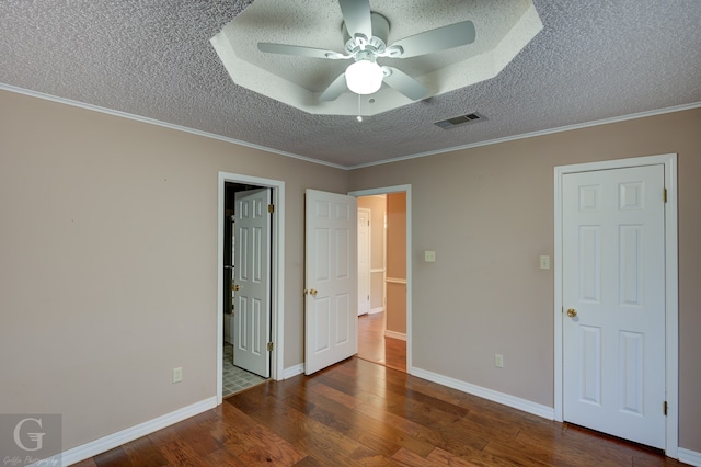 unfurnished bedroom featuring ceiling fan, a textured ceiling, dark hardwood / wood-style floors, and crown molding