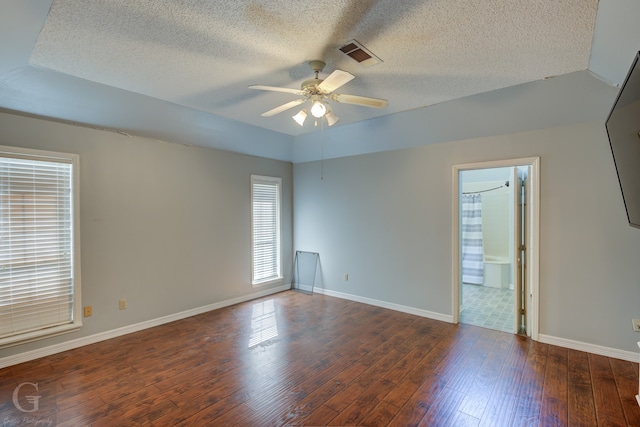 empty room with ceiling fan, dark hardwood / wood-style floors, and a textured ceiling