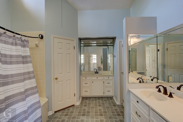 bathroom with a textured ceiling, tile patterned flooring, vanity, and curtained shower