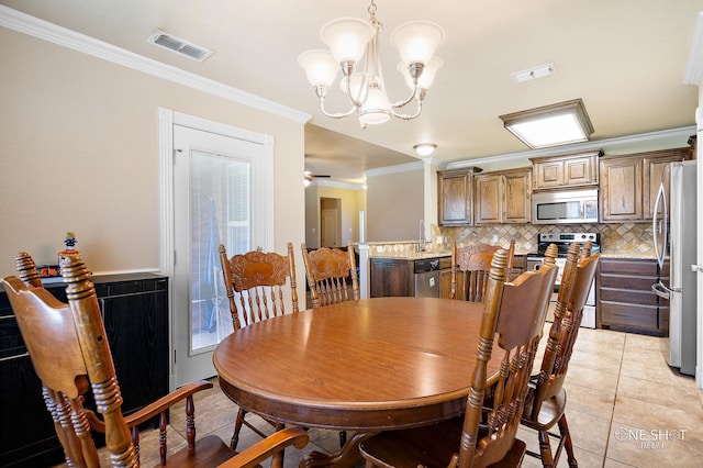 tiled dining area with ceiling fan with notable chandelier and ornamental molding