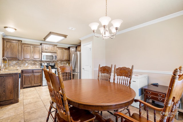 dining space featuring a notable chandelier, sink, ornamental molding, and light tile patterned flooring