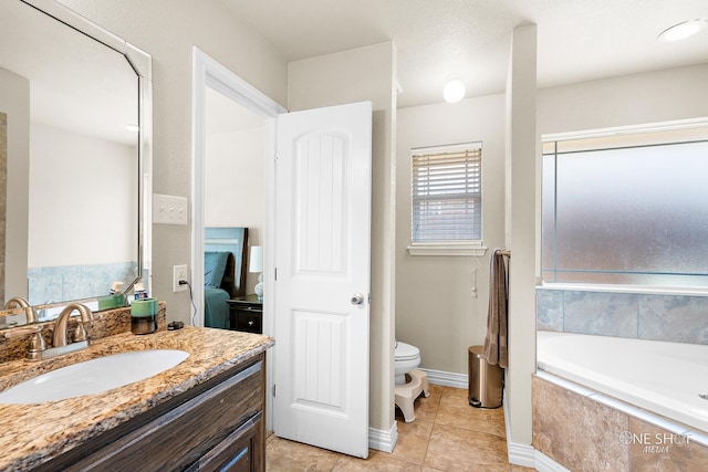 bathroom with tiled bath, vanity, toilet, and tile patterned flooring