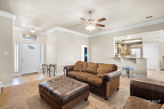 living room with light tile patterned flooring, ornamental molding, sink, and ceiling fan