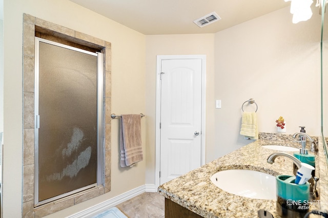 bathroom with tile patterned flooring, a shower with shower door, and vanity