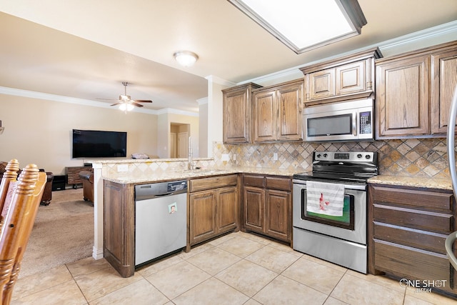 kitchen featuring light tile patterned flooring, kitchen peninsula, stainless steel appliances, ceiling fan, and sink