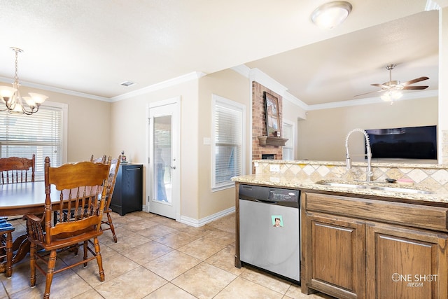 kitchen featuring dishwasher, sink, ceiling fan with notable chandelier, a brick fireplace, and decorative light fixtures