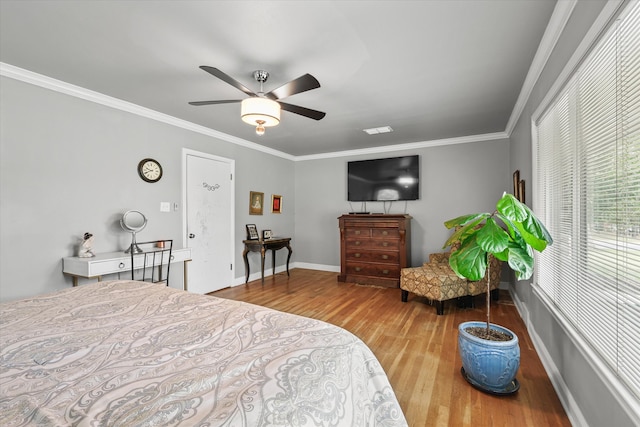 bedroom featuring ornamental molding, wood-type flooring, and ceiling fan