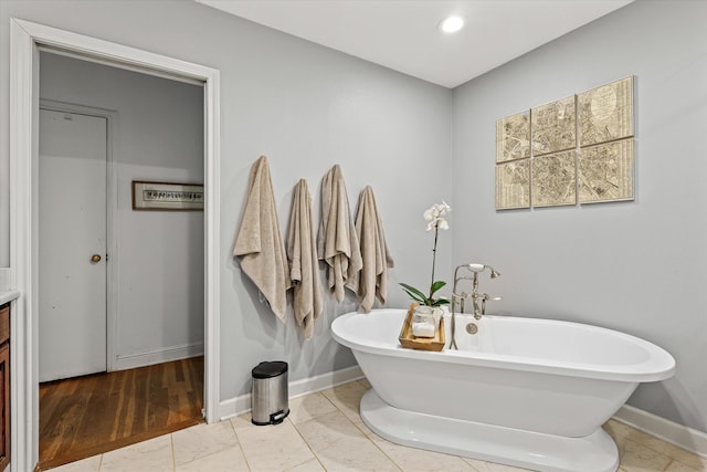 bathroom featuring vanity, a bathtub, and hardwood / wood-style flooring