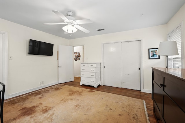 unfurnished bedroom with ceiling fan, a closet, and hardwood / wood-style floors