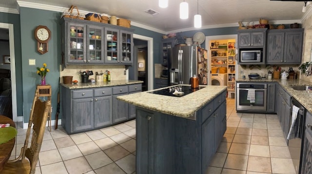 kitchen with appliances with stainless steel finishes, hanging light fixtures, tasteful backsplash, a kitchen island, and ornamental molding