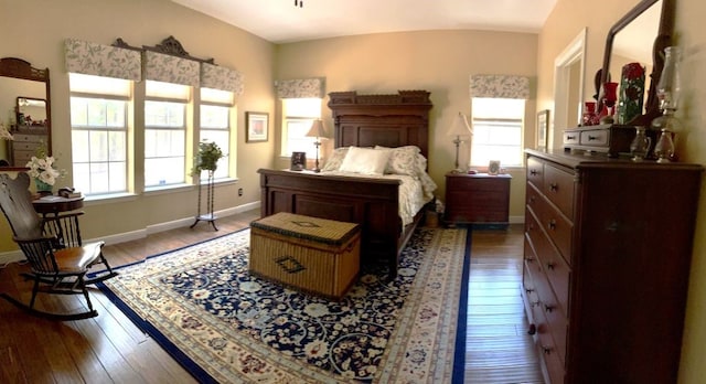 bedroom featuring multiple windows, wood-type flooring, and lofted ceiling