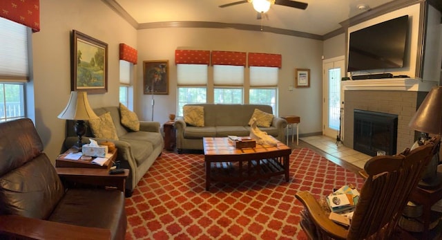 living room featuring a brick fireplace, ceiling fan, light tile patterned floors, and crown molding