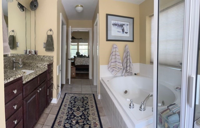 bathroom with a relaxing tiled tub, tile patterned floors, and vanity