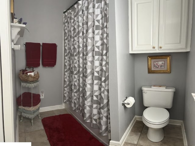 bathroom featuring tile patterned flooring, curtained shower, and toilet