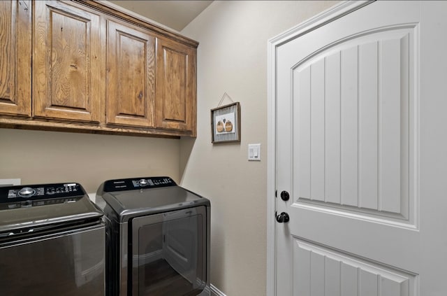 clothes washing area with cabinets and independent washer and dryer