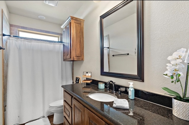 bathroom featuring a shower with shower curtain, vanity, and toilet