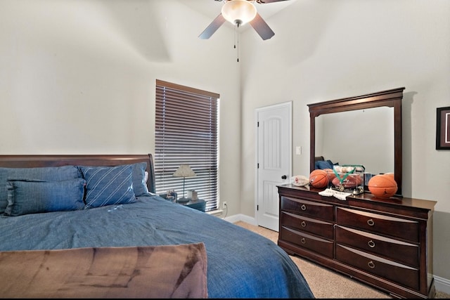 carpeted bedroom featuring ceiling fan and a high ceiling