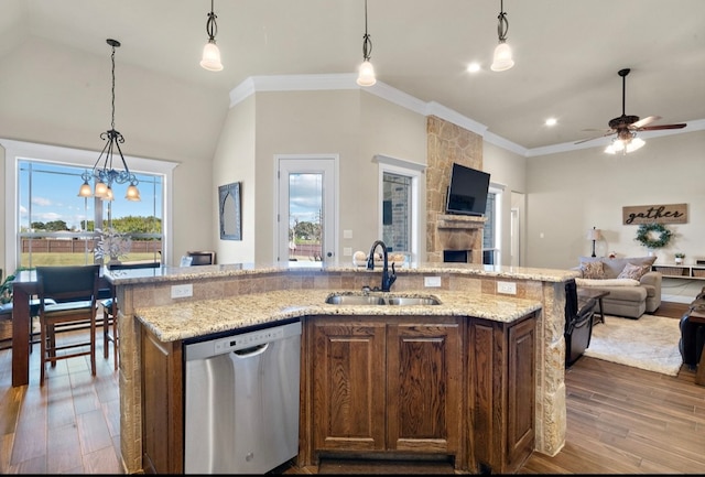 kitchen featuring pendant lighting, a center island with sink, sink, stainless steel dishwasher, and wood-type flooring