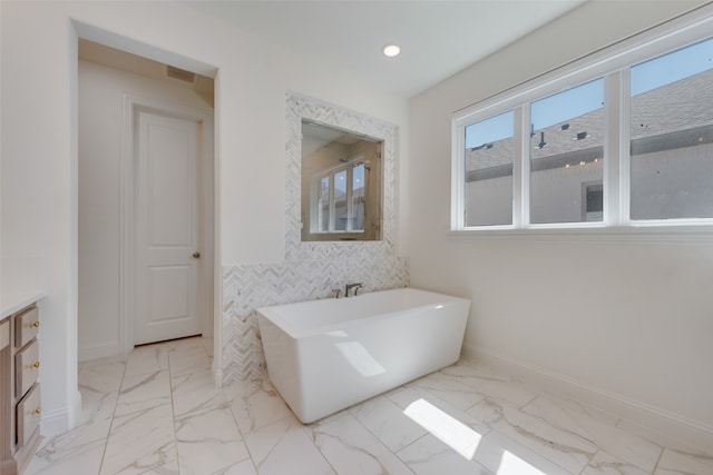 bathroom with a washtub and vanity