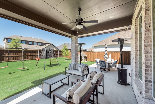 view of patio / terrace with an outdoor living space, ceiling fan, and a playground