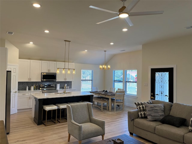 214 E 15th Ave, Corsicana, TX 75110 - living area with vaulted ceiling, light wood finished floors, a chandelier, ceiling fan, and recessed lighting