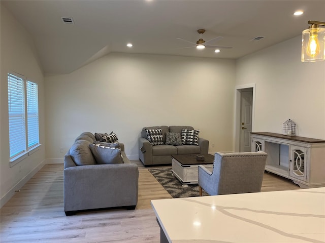 living room with ceiling fan, lofted ceiling, and light wood-type flooring